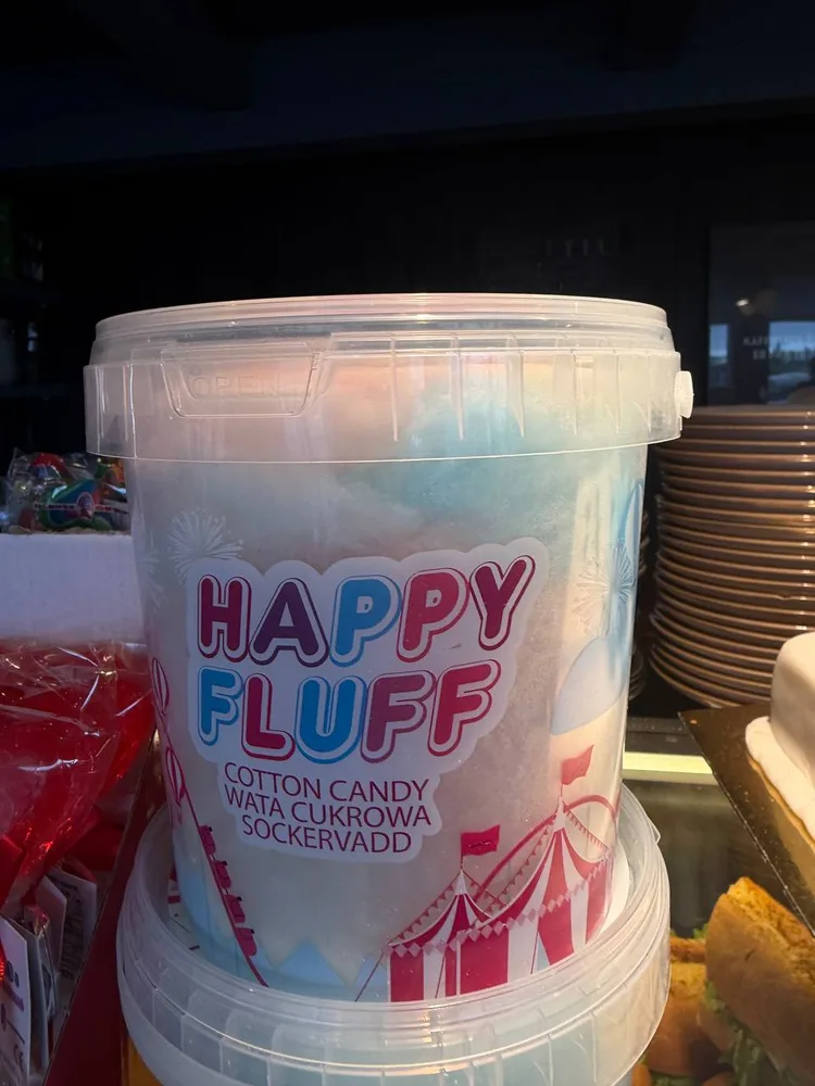 A tub of cotton candy labeled HAPPY FLUFF on a café shelf.